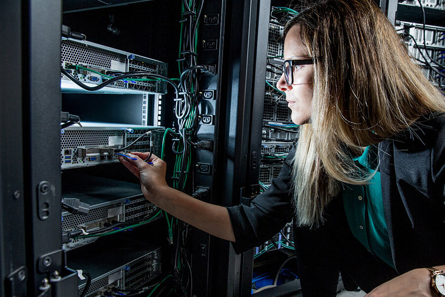 Una técnica informática conecta un cable de red a un servidor montado en un rack en un centro de datos.